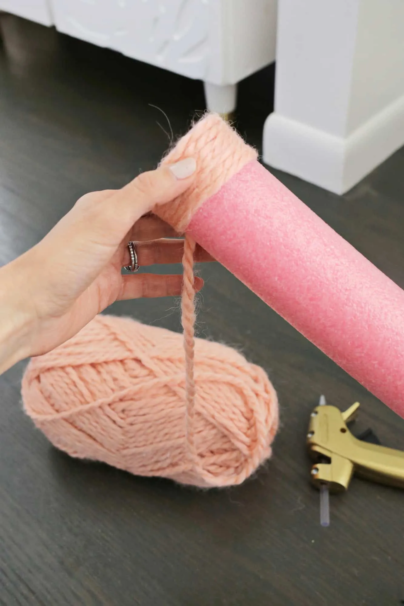 Yarn wrapped around a pink pool noodle