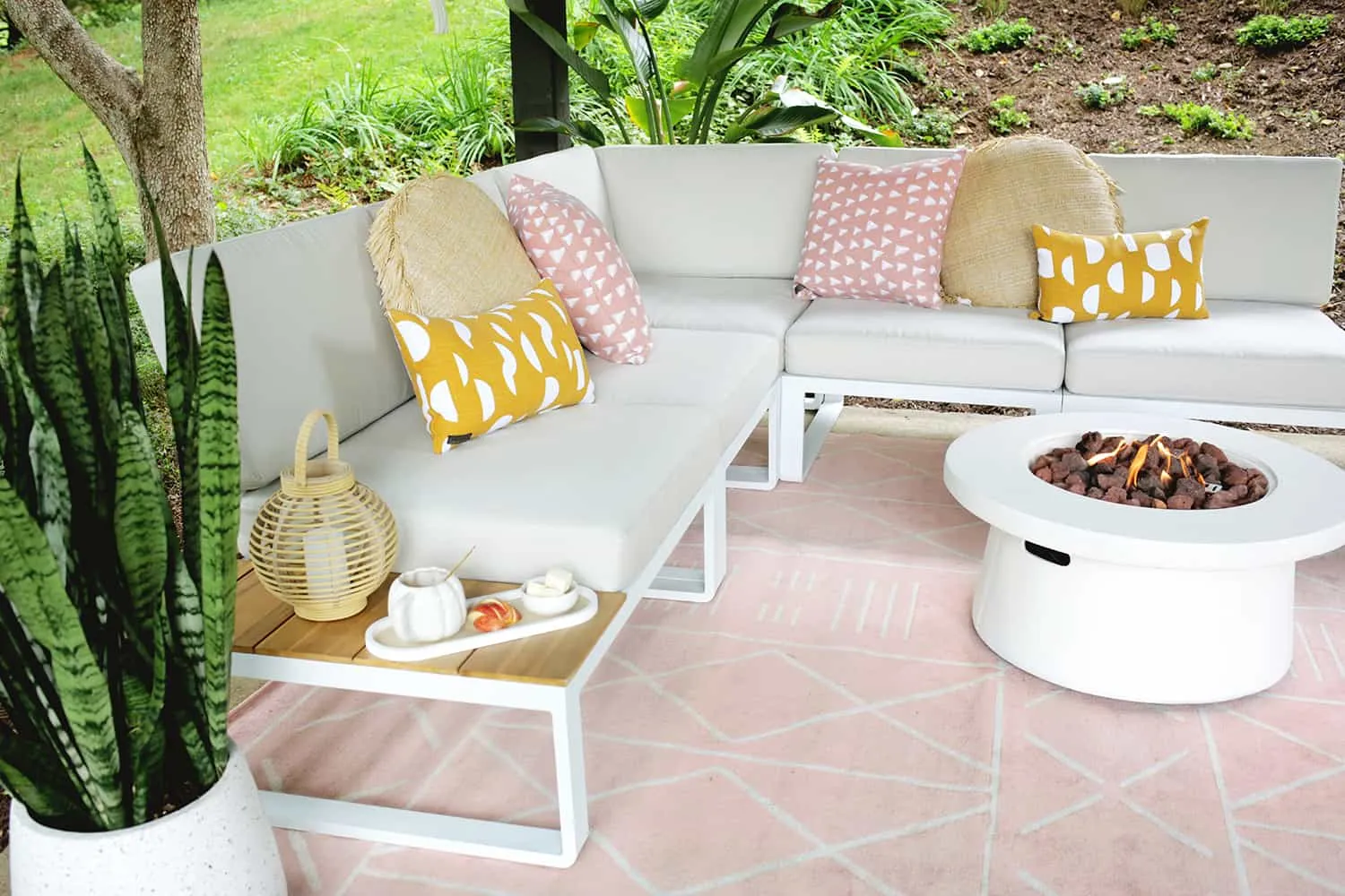 Outdoor pavilion with a pink rug and terrazzo planters