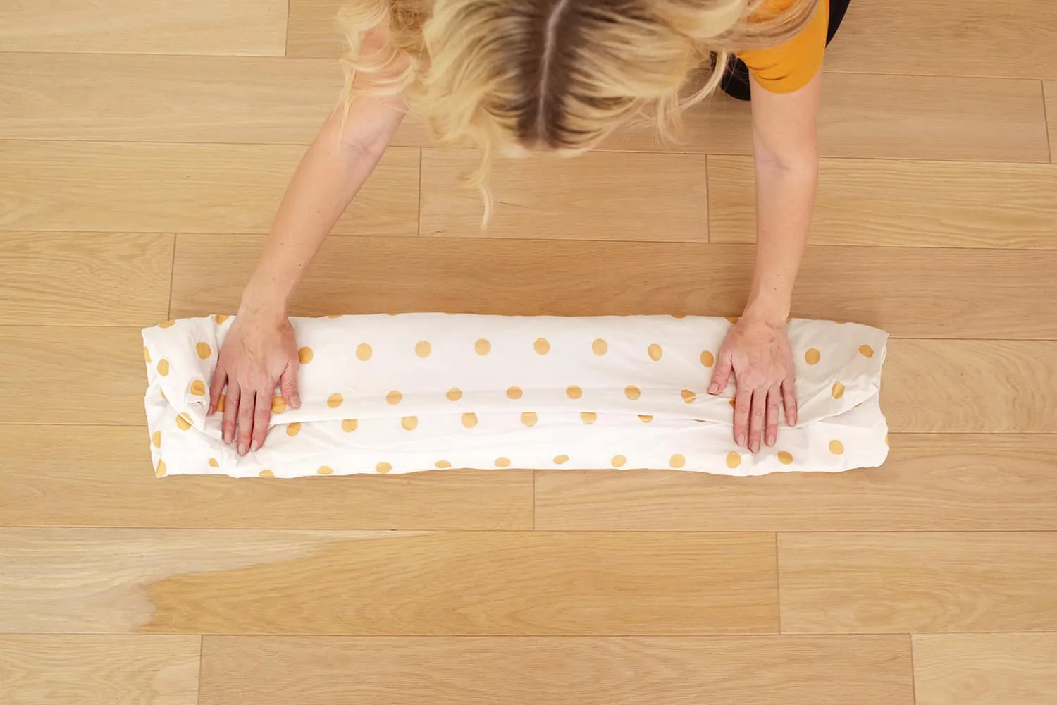 demonstrating how to fold a fitted sheet